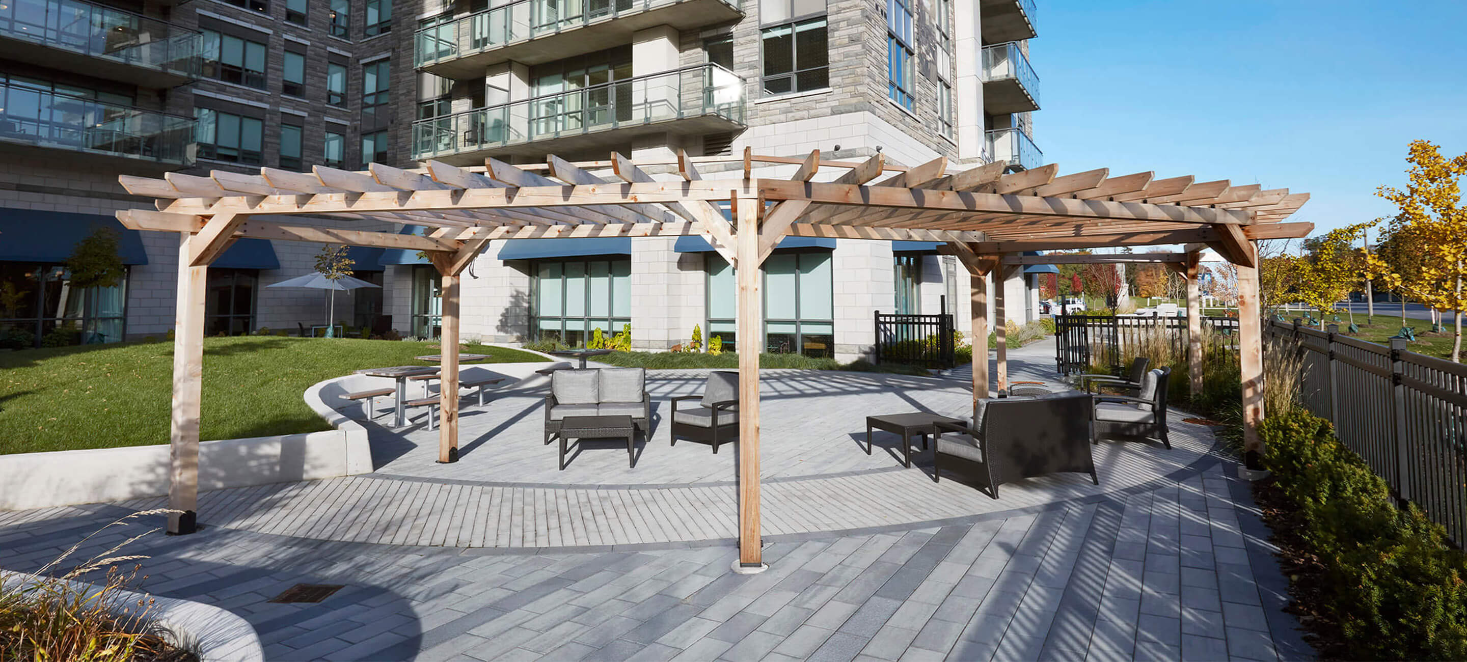 Outdoor seating area outside retirement home with chairs and tables under gazebo