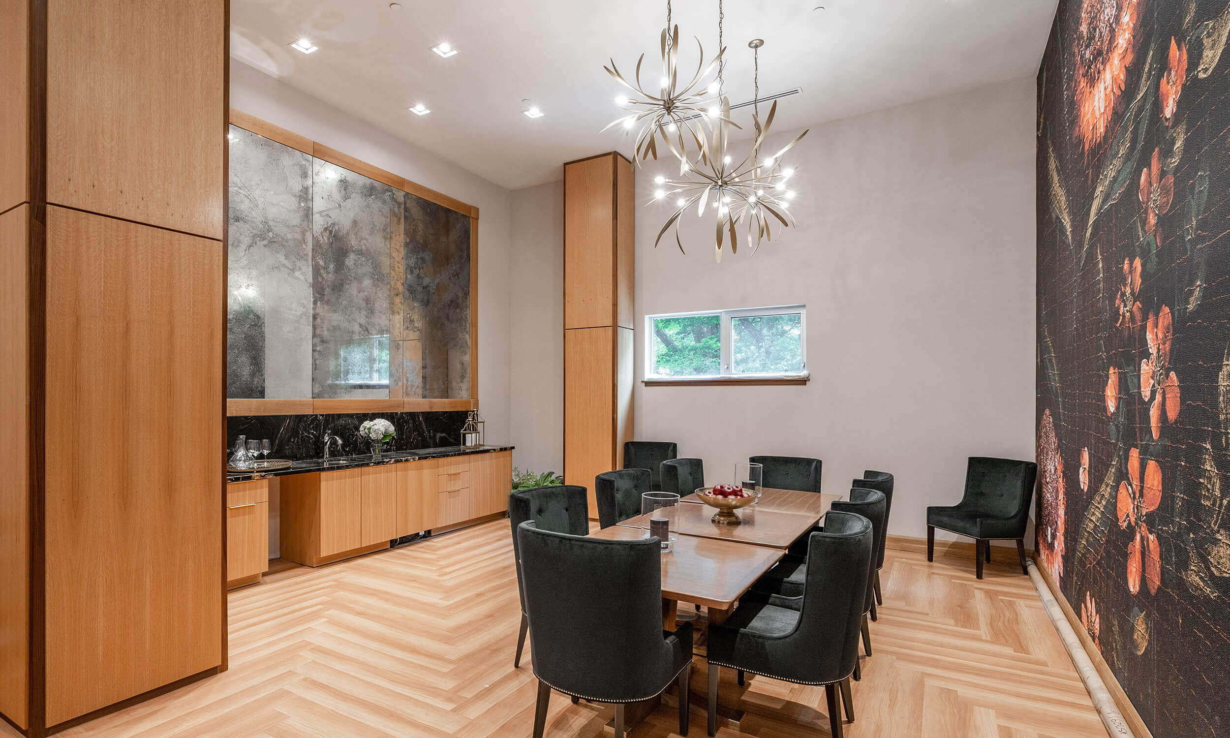 Dining room in Parkland facility with set table and high ceiilings with black floral art on wall, and wood flooring