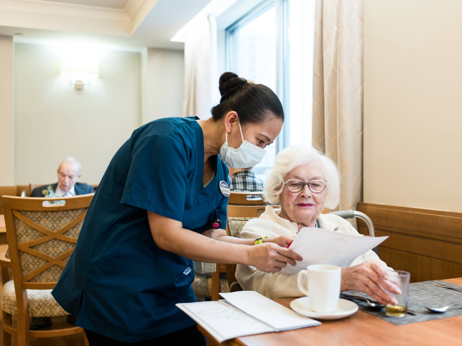 A Parkland team member helping a resident read a menu. 